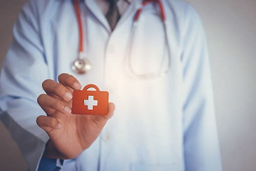 Benefits betriebliche Krankenversicherung | Arzt mit weißem Kittel und kleinem Arztkoffer in der Hand