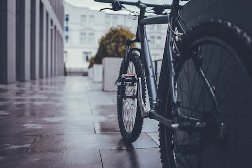 Benefits Dienstfahrrad | schwarzes Fahrrad steht in einer Stadt angelehnt an einer Wand