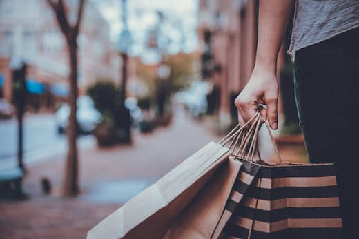 Benefits Sachbezug Shopping Gutschein | Person auf öffentlicher Straße mit Einkaufstüten in der Hand